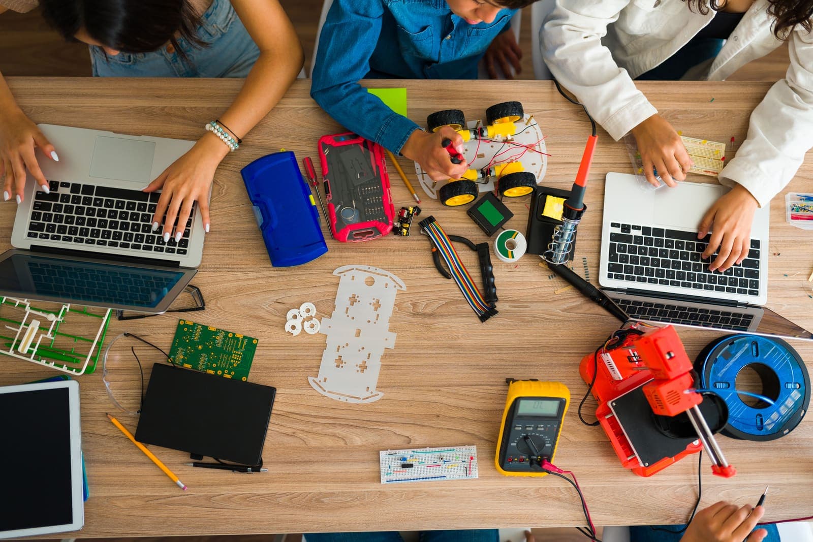 High-school students working on laptops in a community space.